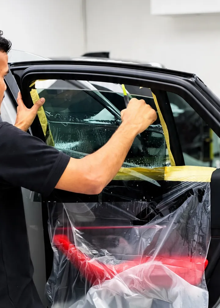 Window tint being fitted to a car at Apex Detail Studio Dubai