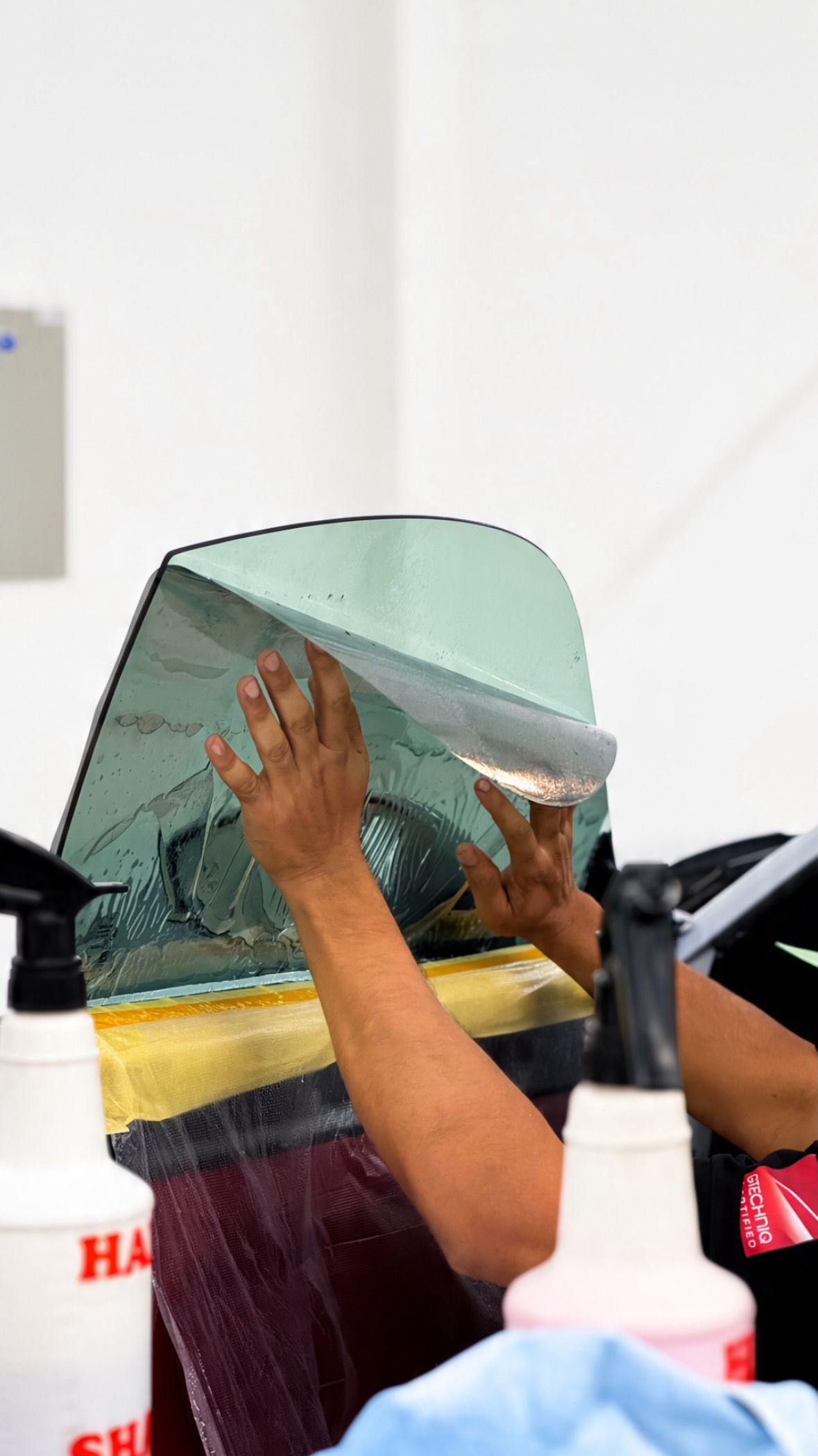 Window film being heat-shrunk to curved car glass at Apex Detail Studio