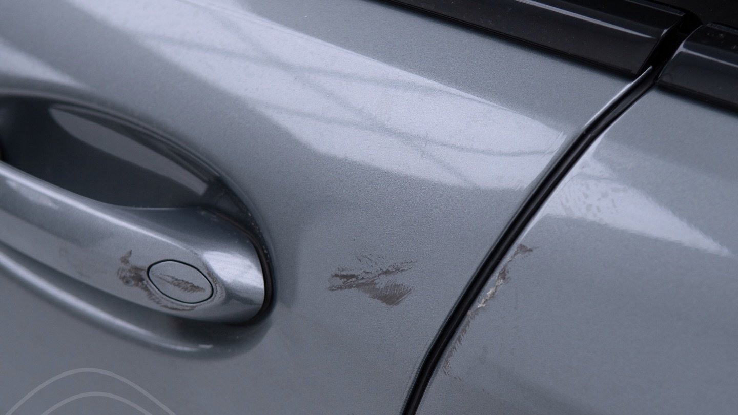 BMW 850i door with scratches and a dent before paint repair at Apex Detail Studio, Dubai