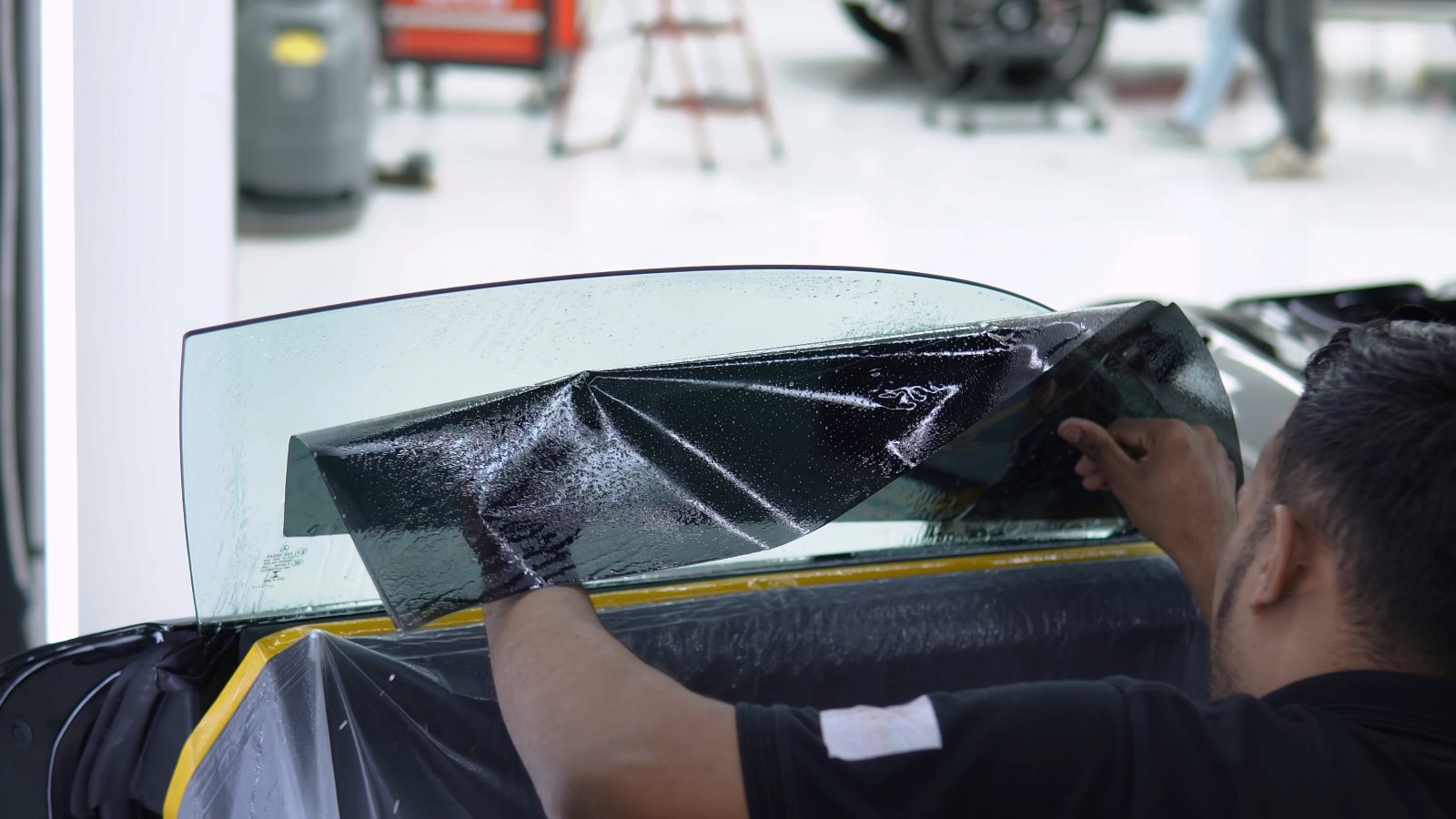 Window film being laid on the door glass of a Mercedes-AMG GT Black Series