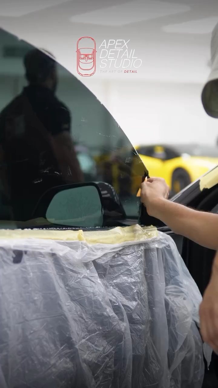Tesla Model 3 door protected with a cover while tint is fitted in Dubai