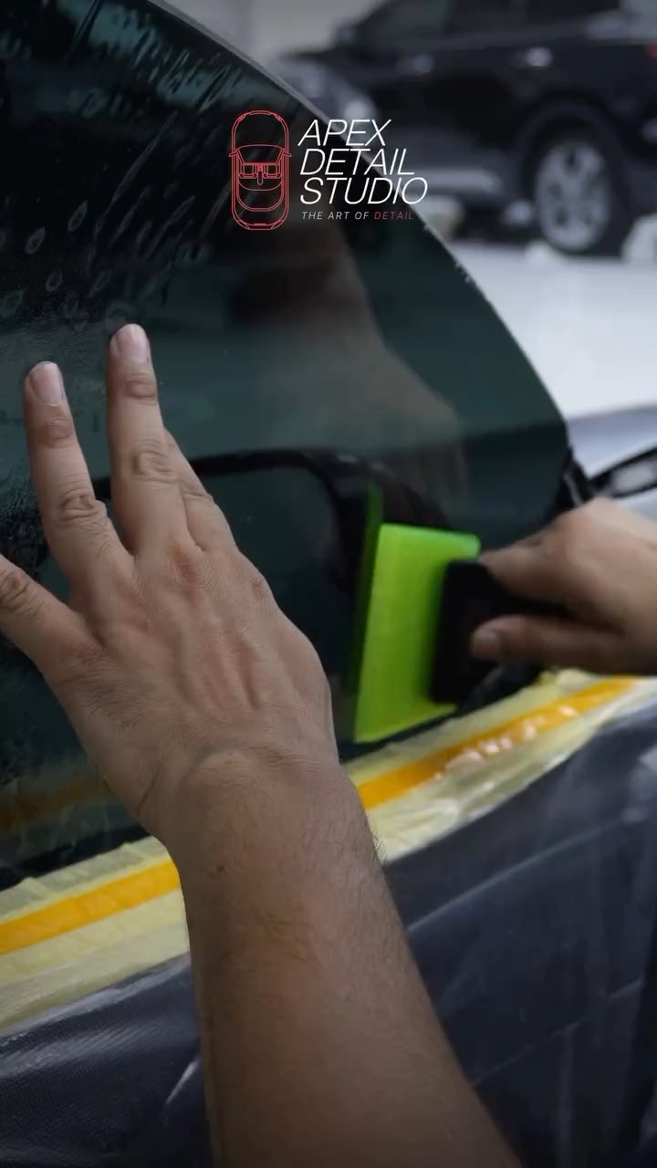 Squeegee pushing water out of the Tesla Model S Plaid tint at Apex Detail Studio